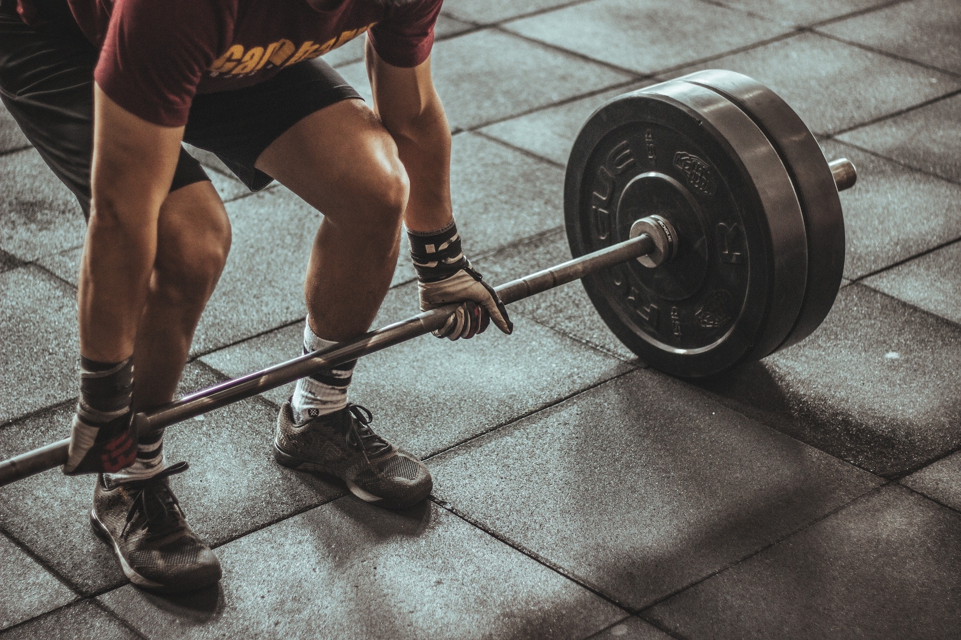 un hombre sujetando una barra en el gimnasio